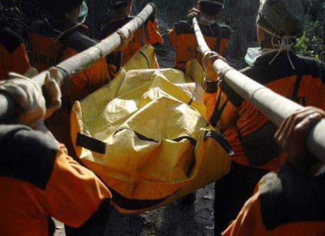 Спасатели несут тело с места аварии "Суперджета"